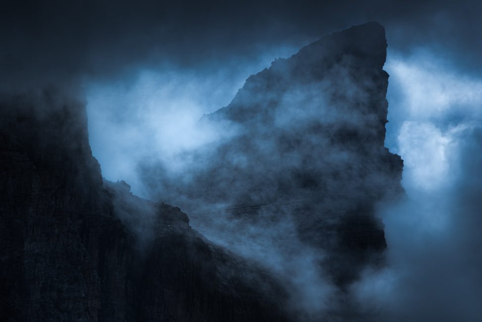 Bastione roccioso avvolto da nuvole ed effetti di luce fredda, fotografia di paesaggio intimista per il progetto The Dark Side.