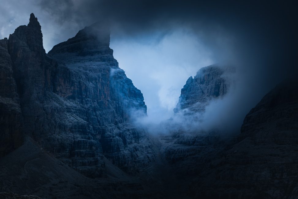 Gola tra pareti rocciose avvolta da nubi e luce fredda, fotografia di paesaggio evocativa per il progetto The Dark Side.