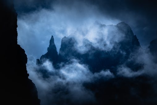 Guglia alpina nella nebbia con forti contrasti, fotografia di paesaggio artistica per il progetto The Dark Side.