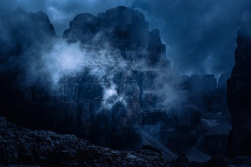 Massiccio roccioso con nebbia leggera e contrasti scuri, fotografia di paesaggio a toni freddi per il progetto The Dark Side.
